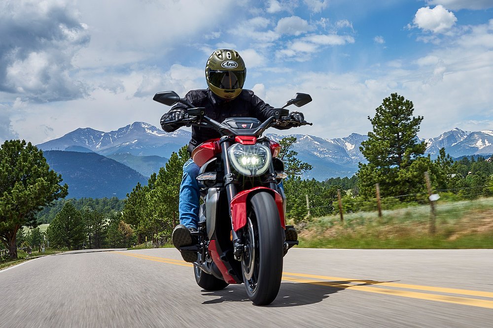 Dustin pilots the XDiavel V4 down the road with snow-dusted mountains in the background.