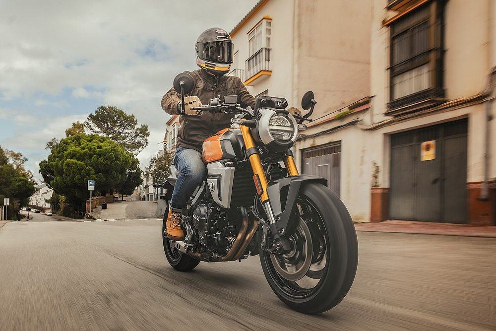 A Suzuki GSX-8T rider plods through a neighborhood.