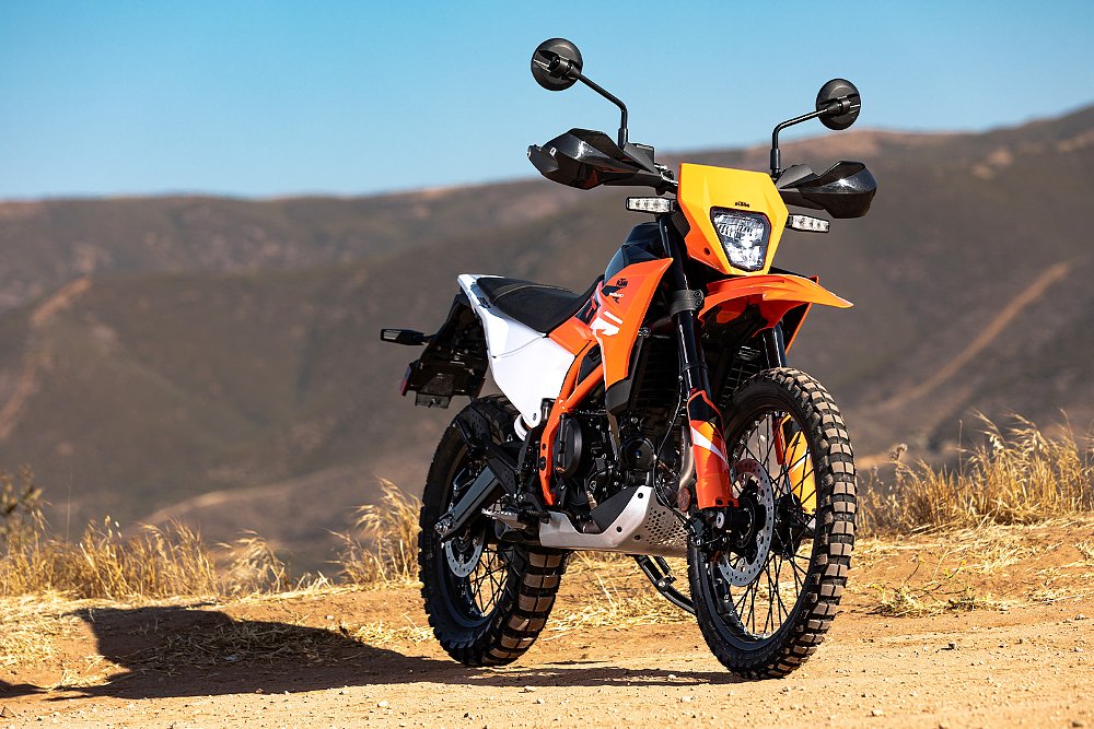 The KTM 390 Enduro R staged on a trail with mountains in the background.