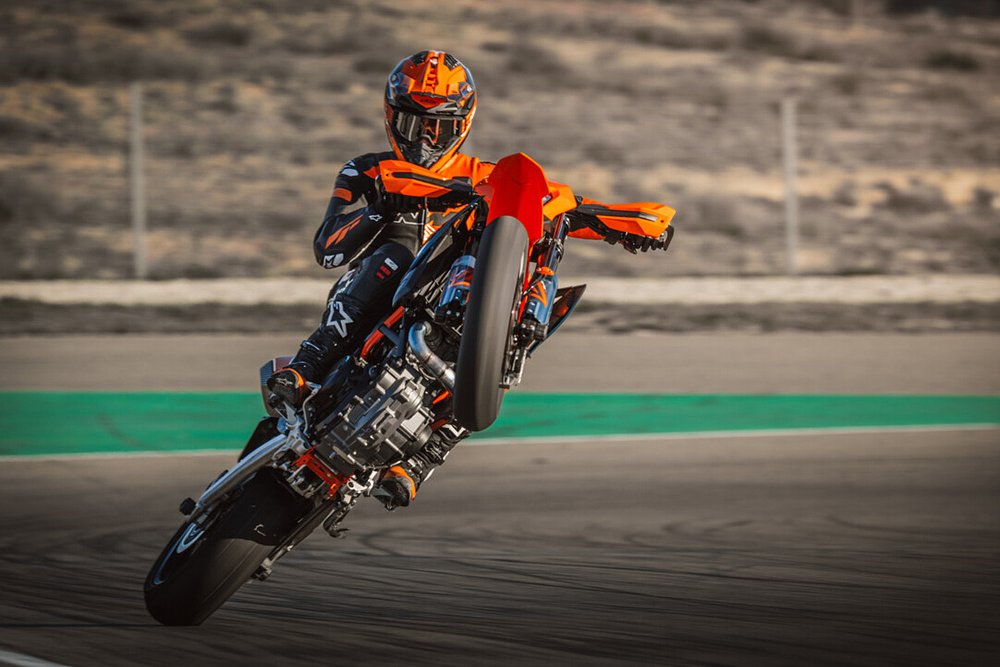 A 690 SMC R rider hucks up a wheelie while riding on a closed track.