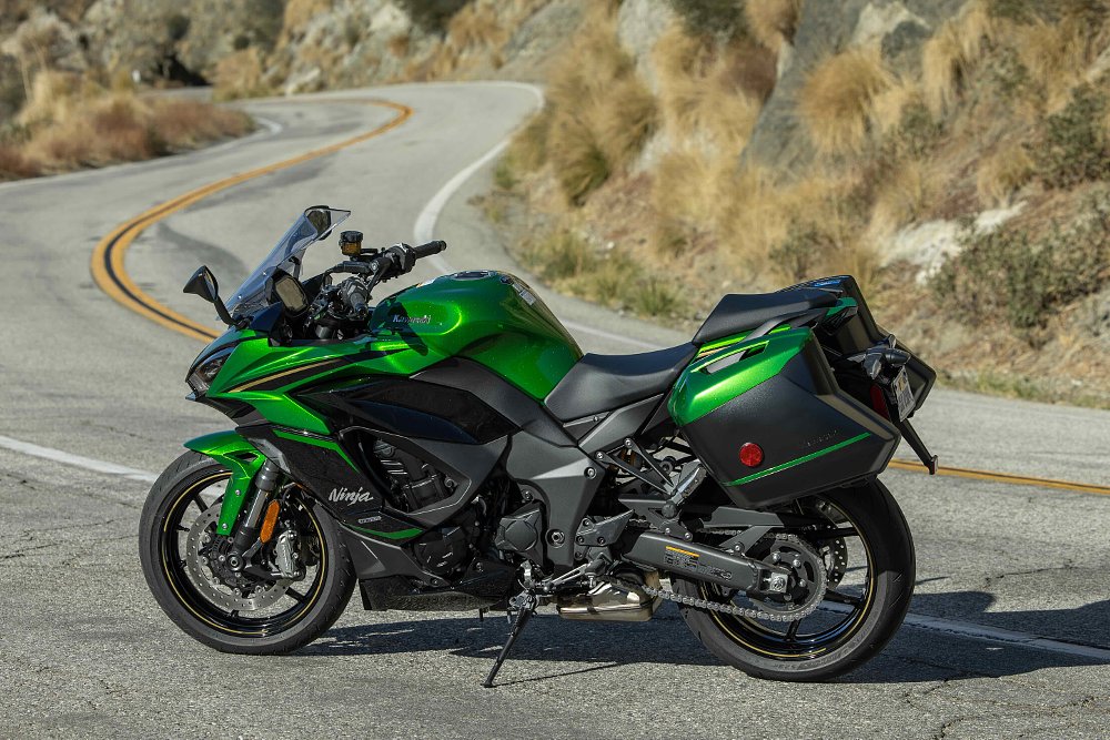 2025 Kawasaki Ninja 1100 SX SE parked with a twisty road in the background.