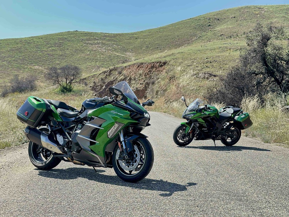 2025 Kawasaki H2 SX SE parked on a mountain road with the 2025 Kawasaki Ninja 1100 SX SE slightly in the background.