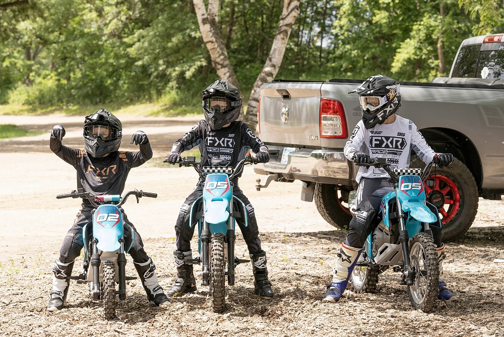 three children on CFMOTO dirt bikes, one on a smaller CFX-2E and two on CFX-5E electric motorcycles