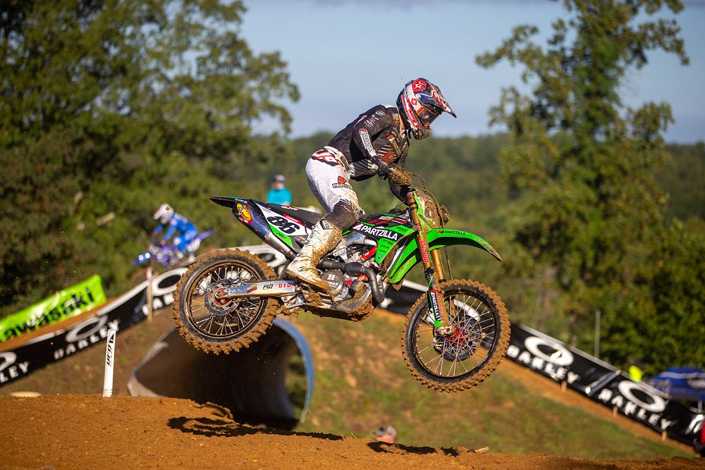 Mitchell Harrison racing his green Kawasaki motocross bike in a race