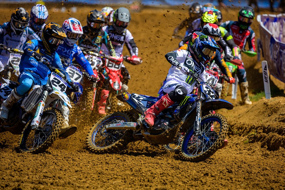 the field tightly bunched at the start of a motocross race