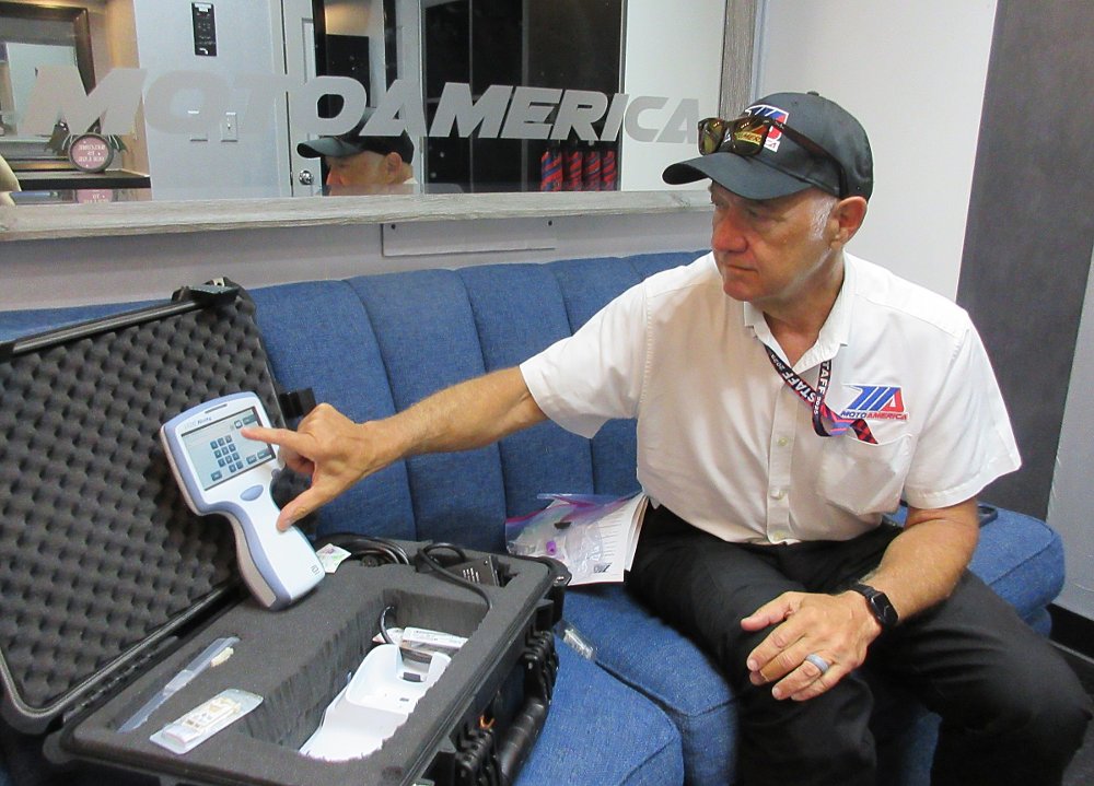 Dr. Price with the handheld testing device from Abbott Labs