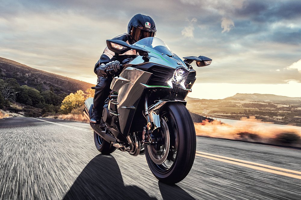 A rider blasts through the countryside aboard the Kawasaki H2.