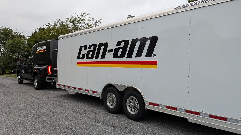 Truck pulling a long trailer with Can-Am logo on the side