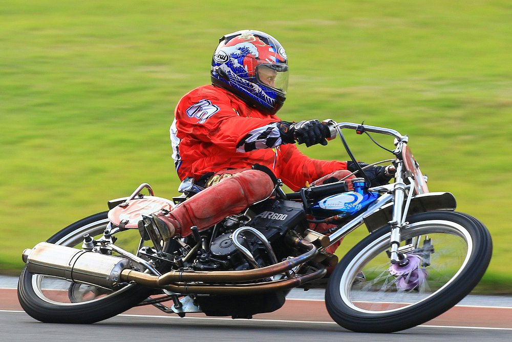 A lone auto racer takes a turn at high speed.