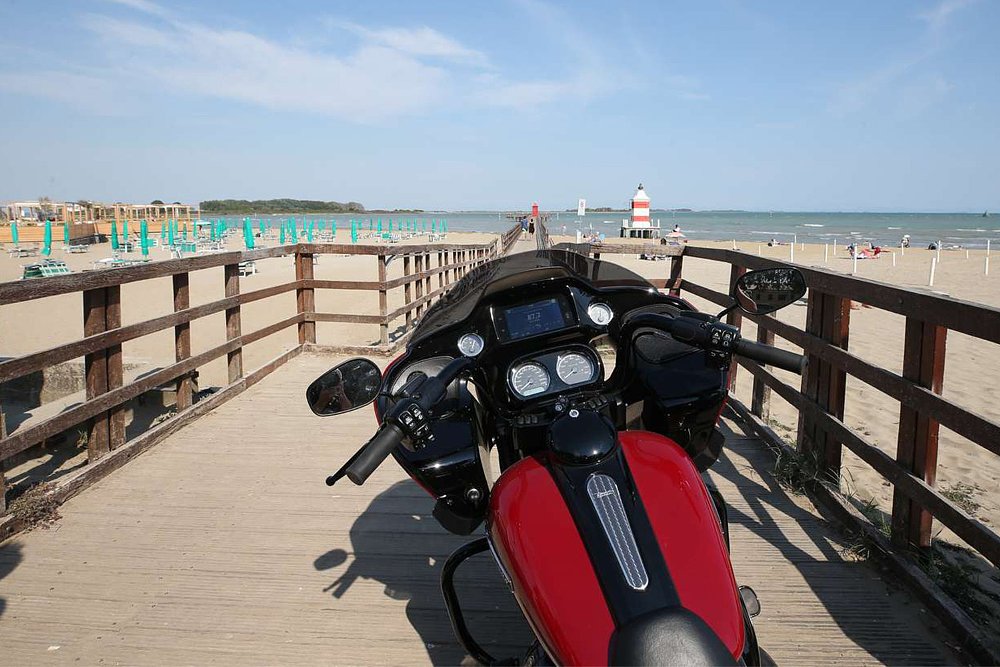 A view of the Adriatic Sea from the cockpit of a Harley-Davidson bagger parked on a Lignano Sabbiadoro dock. 