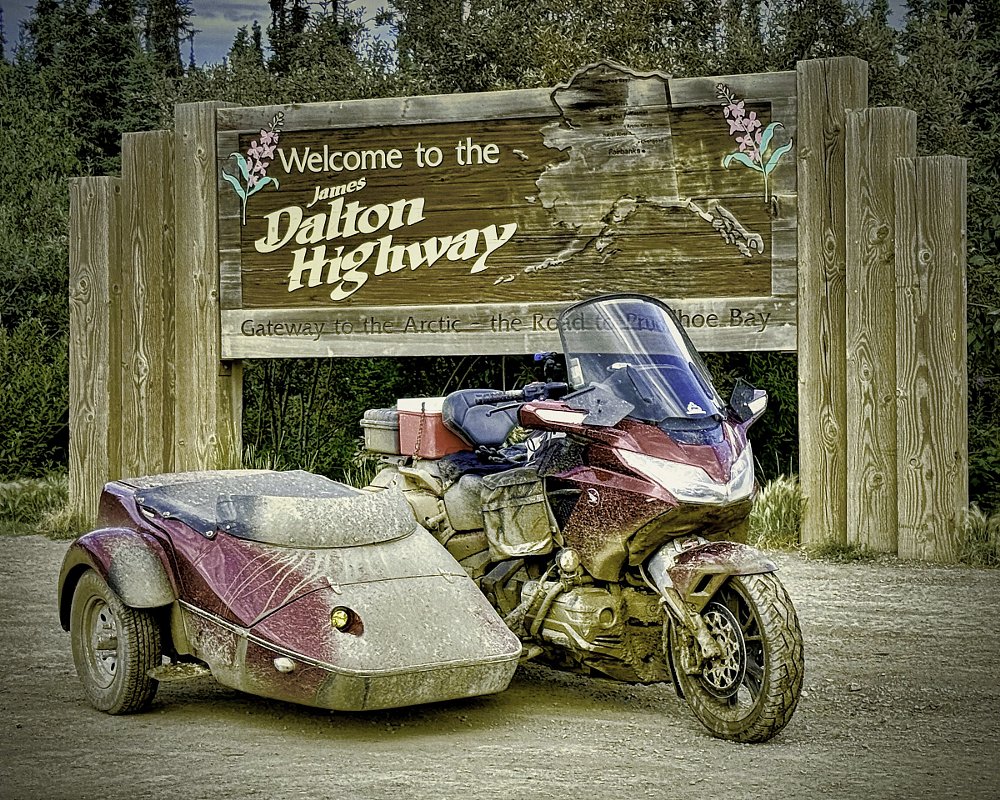Daub's Gold Wing and sidecar in front of a sign marking the beginning of the Dalton Highway