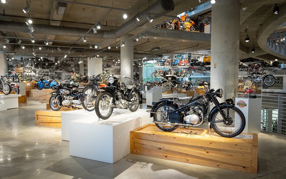 interior view of a portion of the museum with dozens of motorcycles and cars on display