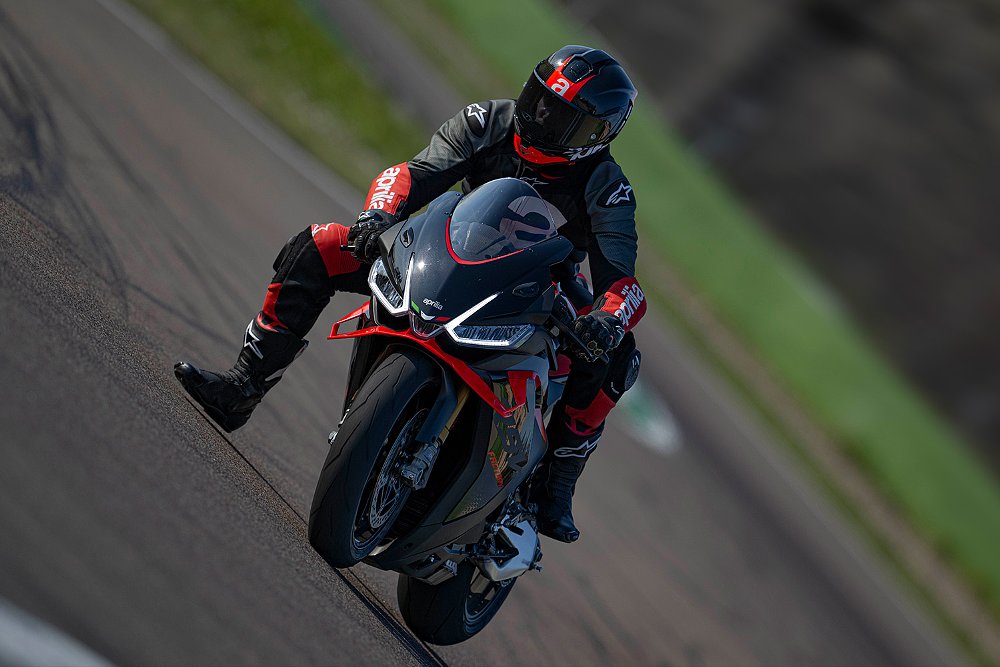 An RSV4 1100 Factory rider brakes heavily into a corner on track.
