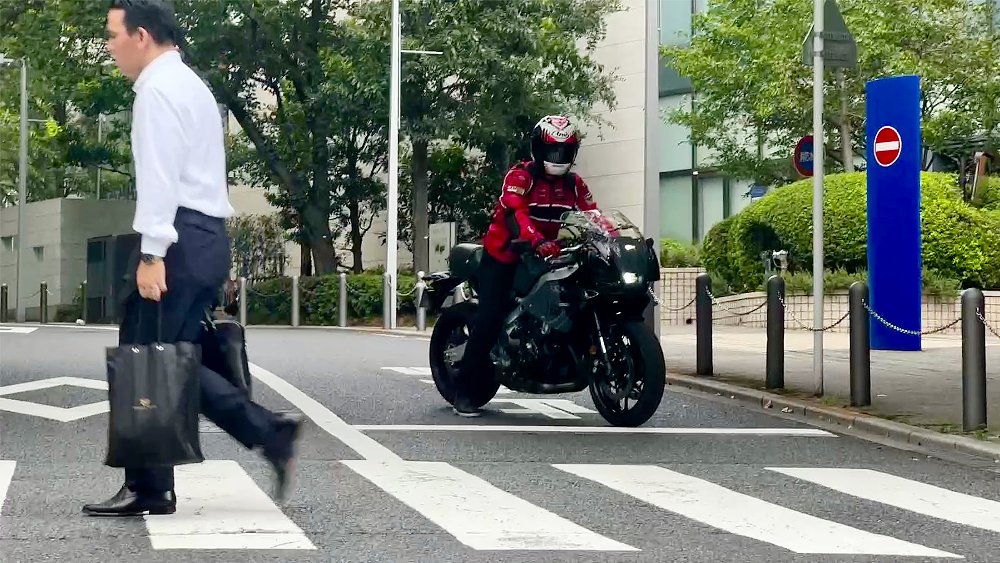 Mounted on a Yamaha XSR900 GP, Dustin waits for pedestrian in the crosswalk.