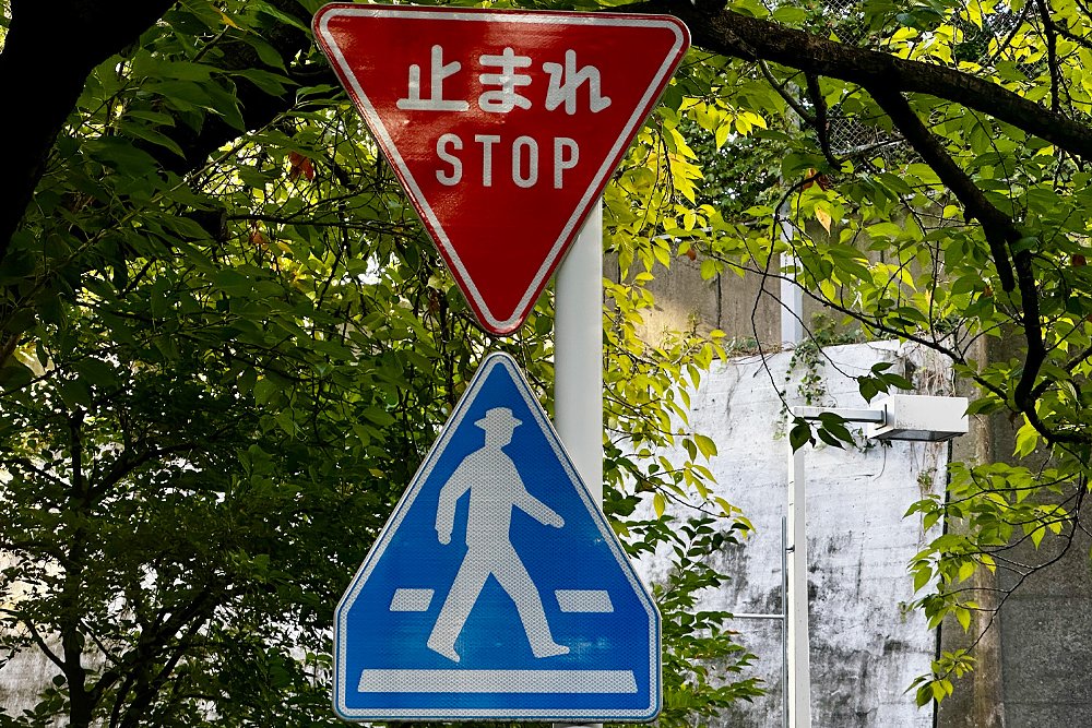 A close-up of Japan's stop sign and crosswalk sign.